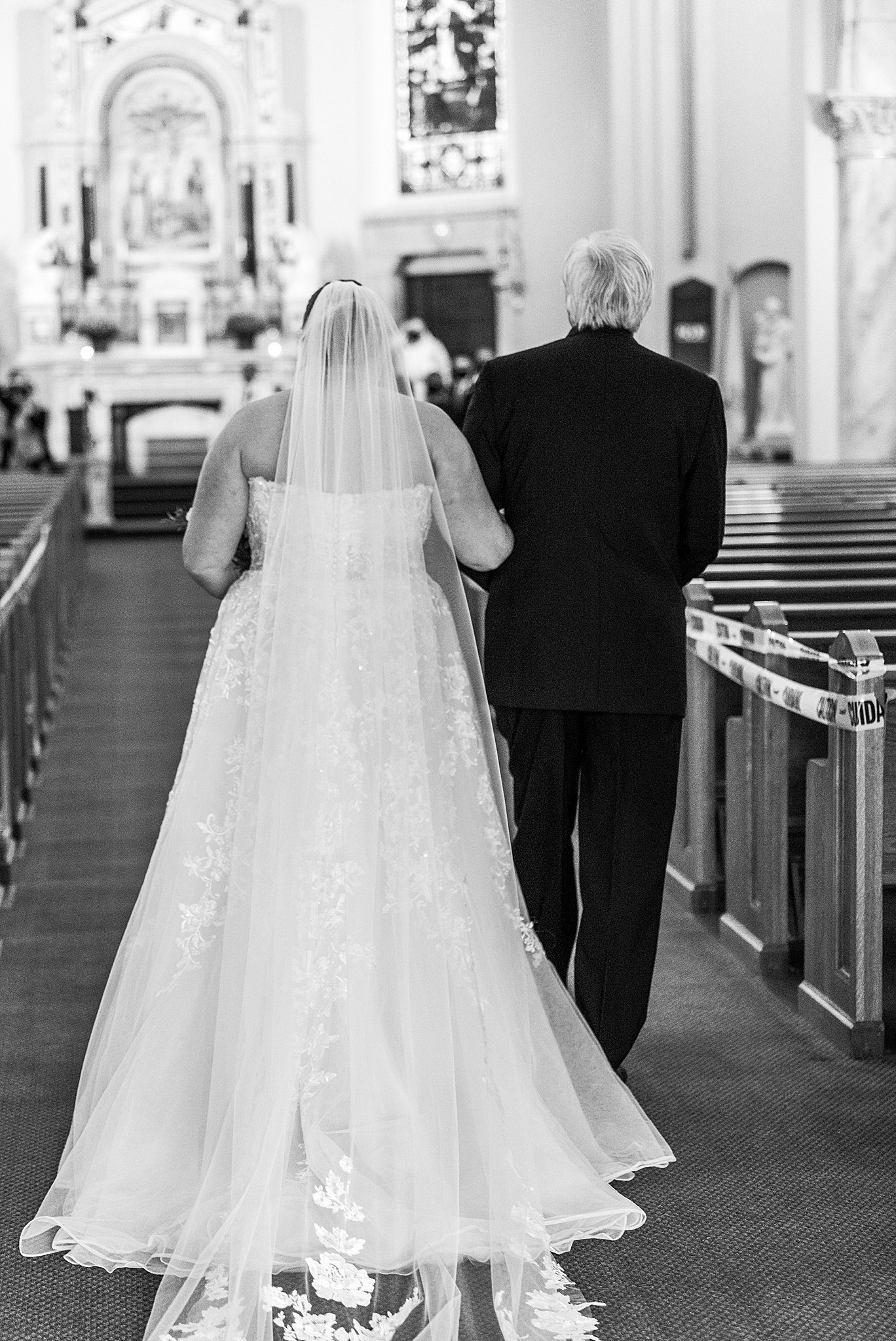 bride walking down aisle of church with father