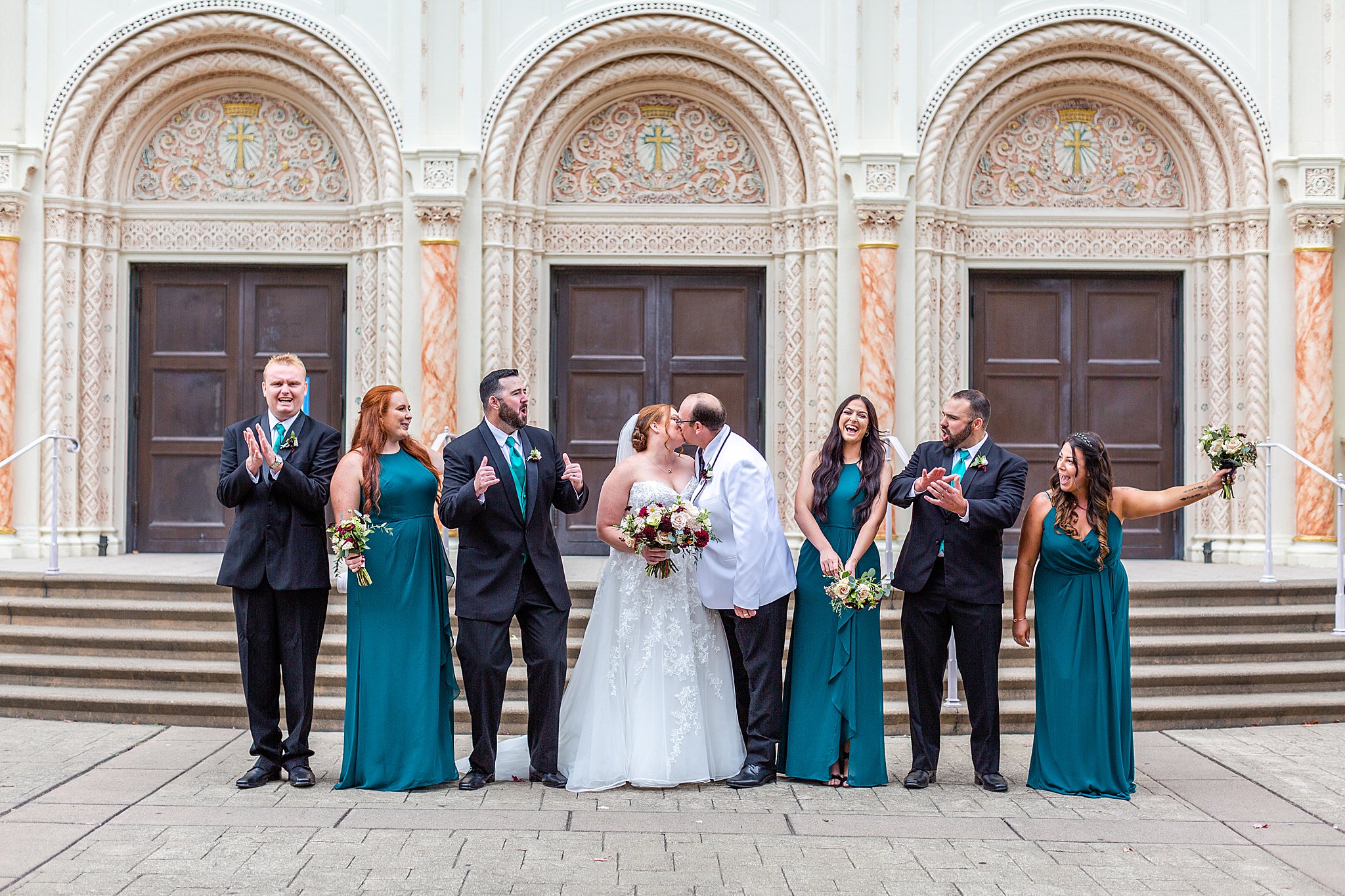 bride and groom with groomsmen and bridesmaids in front of church